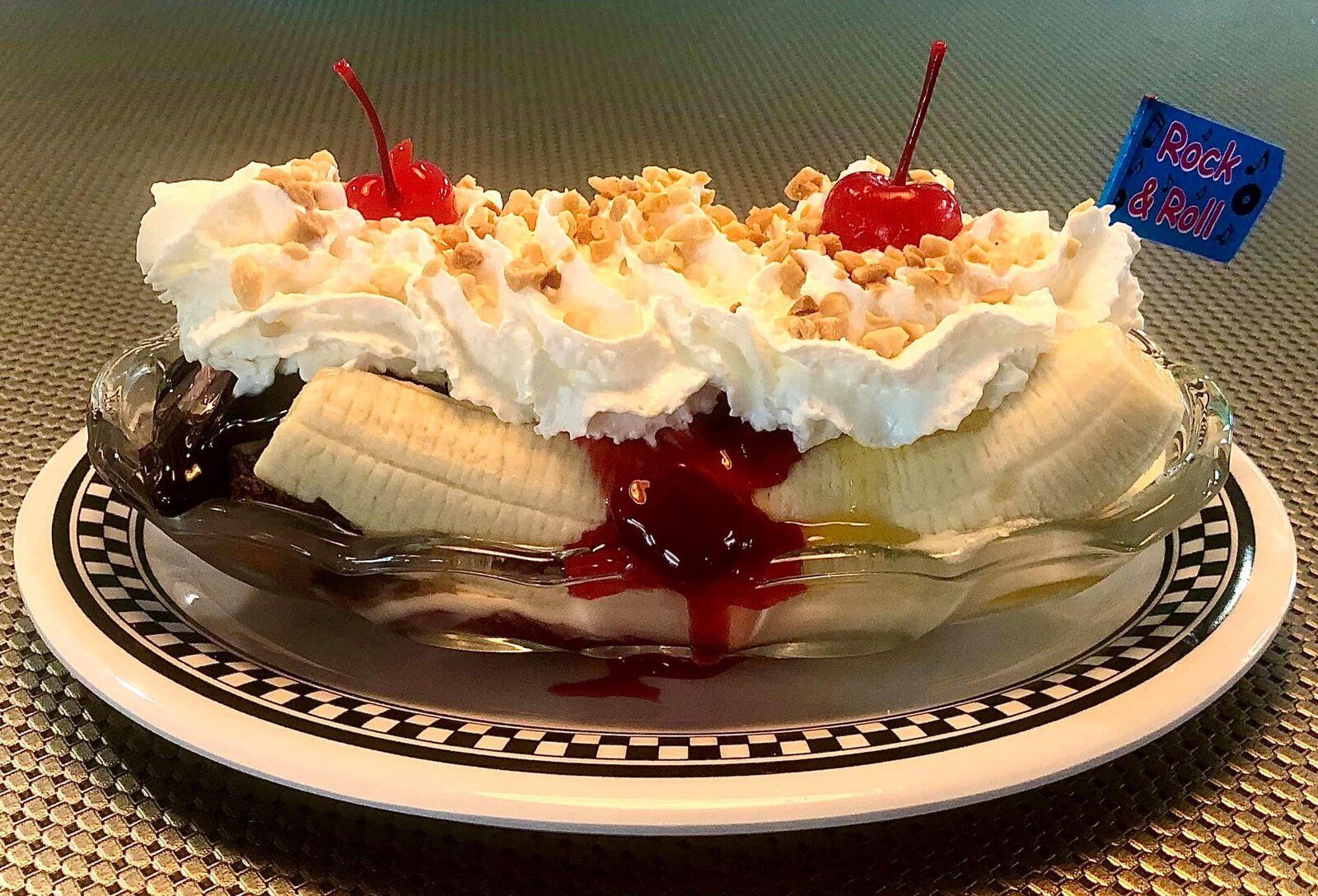 A banana split with whipped cream and cherries
