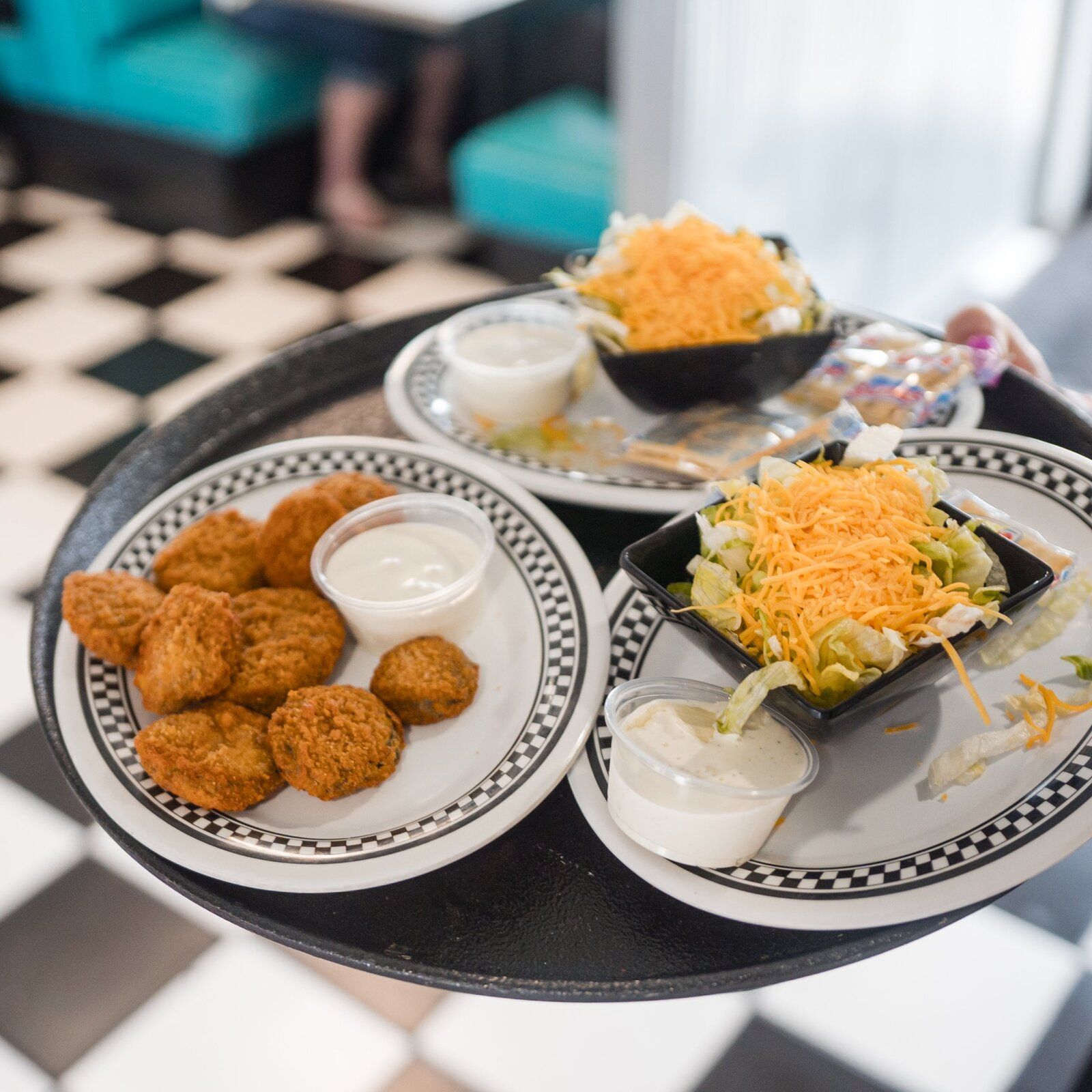 Fried okra with ranch and a side salad on a checkered plate